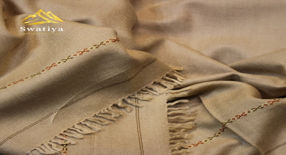 The Swatiya Artisanal Treasures Beige Handwoven Woolen Shawl is a luxurious testament to the timeless art of handweaving.